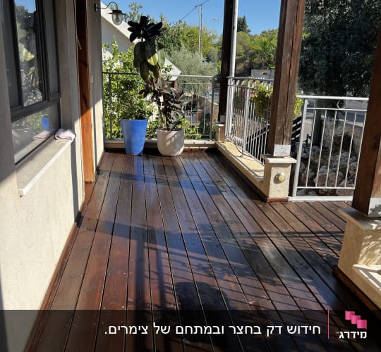 מרפסת עץ עם עציצים וצללים
